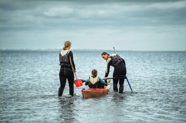 Adventure Efterskolen elever sammen om en kajak på lavt vand